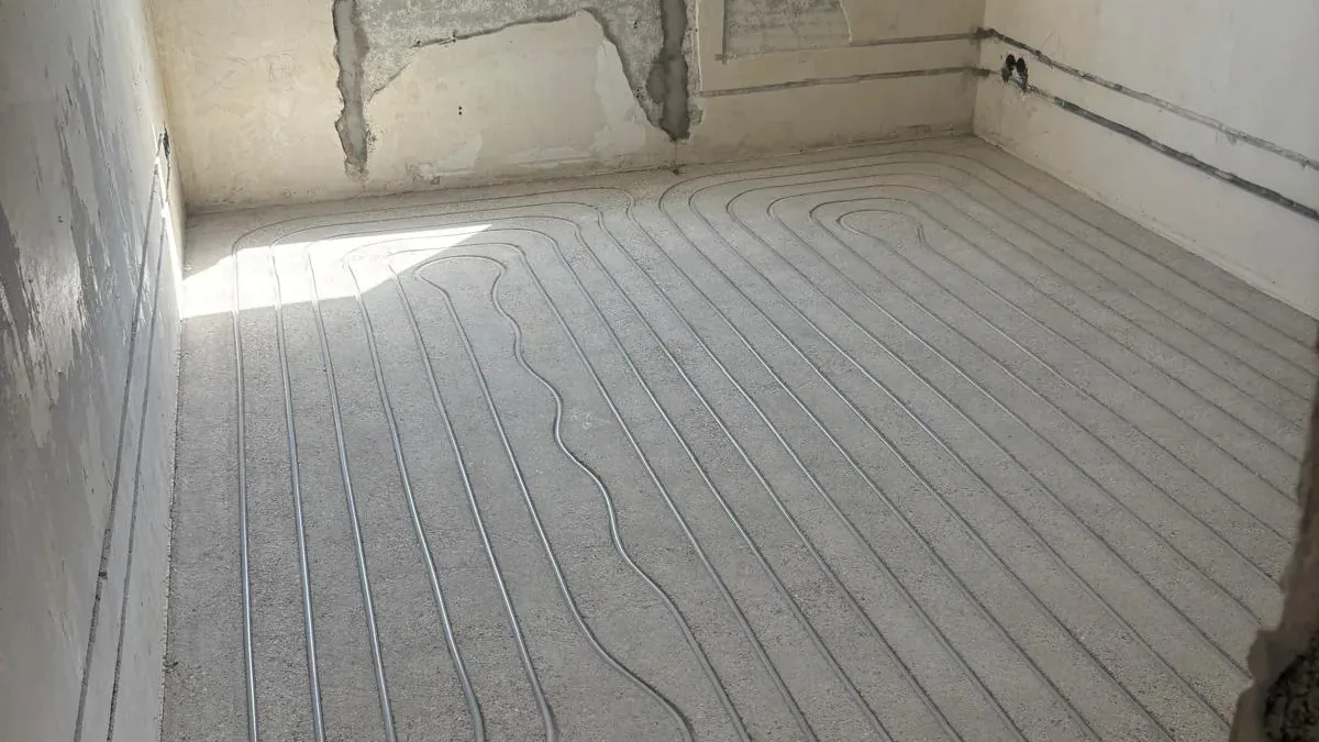 Gefräste Kanäle im Bestandsestrich mit bereits eingelegtem Heizrohr, Tageslicht durch das Fenster